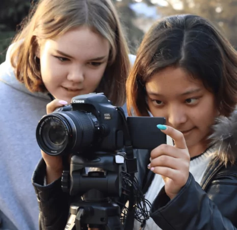 Two young students with a camera