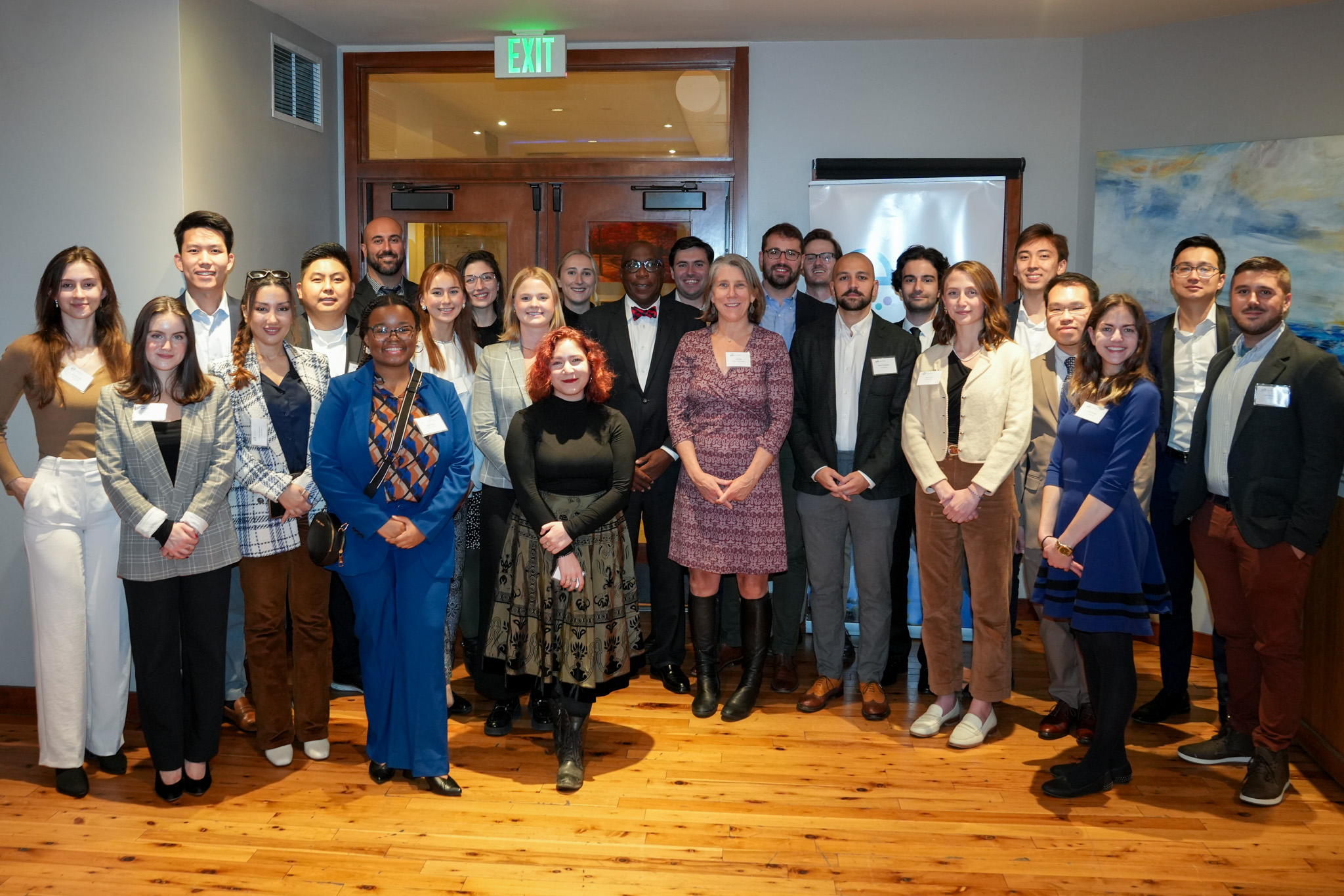 Twenty-five people in business casual attire stand, smiling into the camera. Most of these are YPN fellows; others are EF staff or trustees.