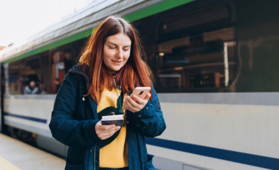 Girl looking at her phone at a train station