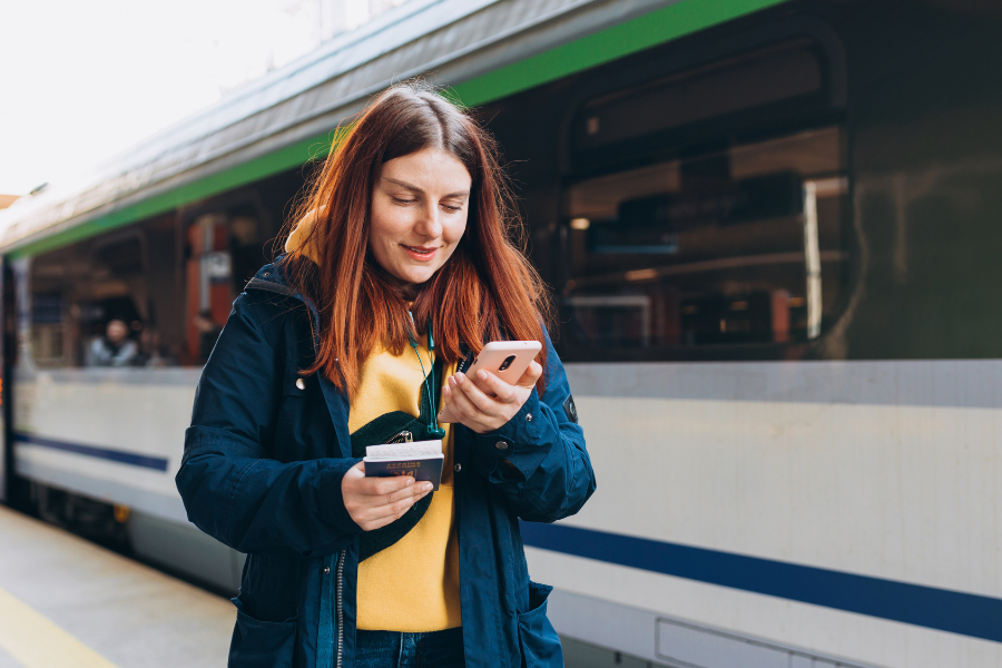 Girl looking at her phone at a train station