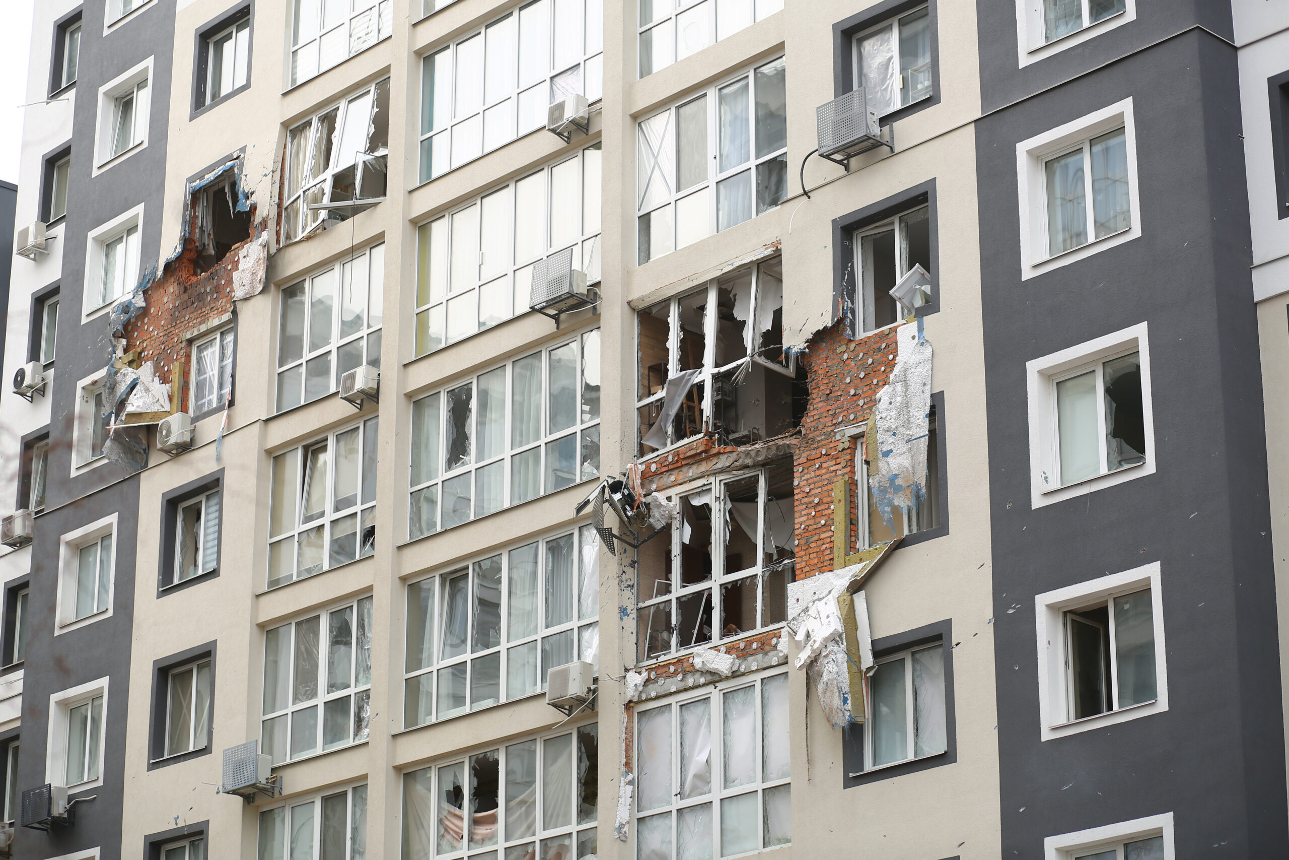 Photo of the side of an apartment building that has sustained significant shelling damage.