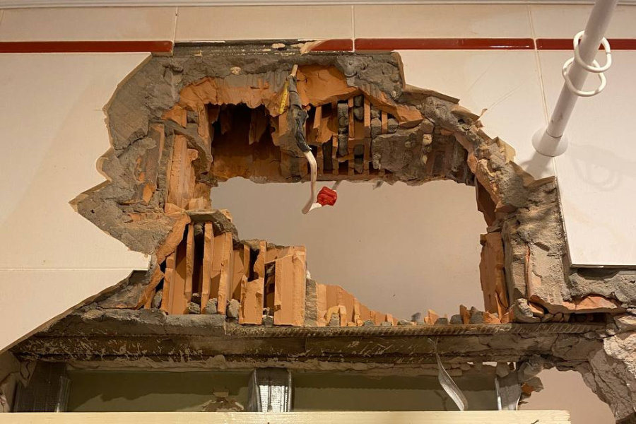 This photo shows a wall with a hole the size of two basketballs caused by warfare in Andrii's apartment.