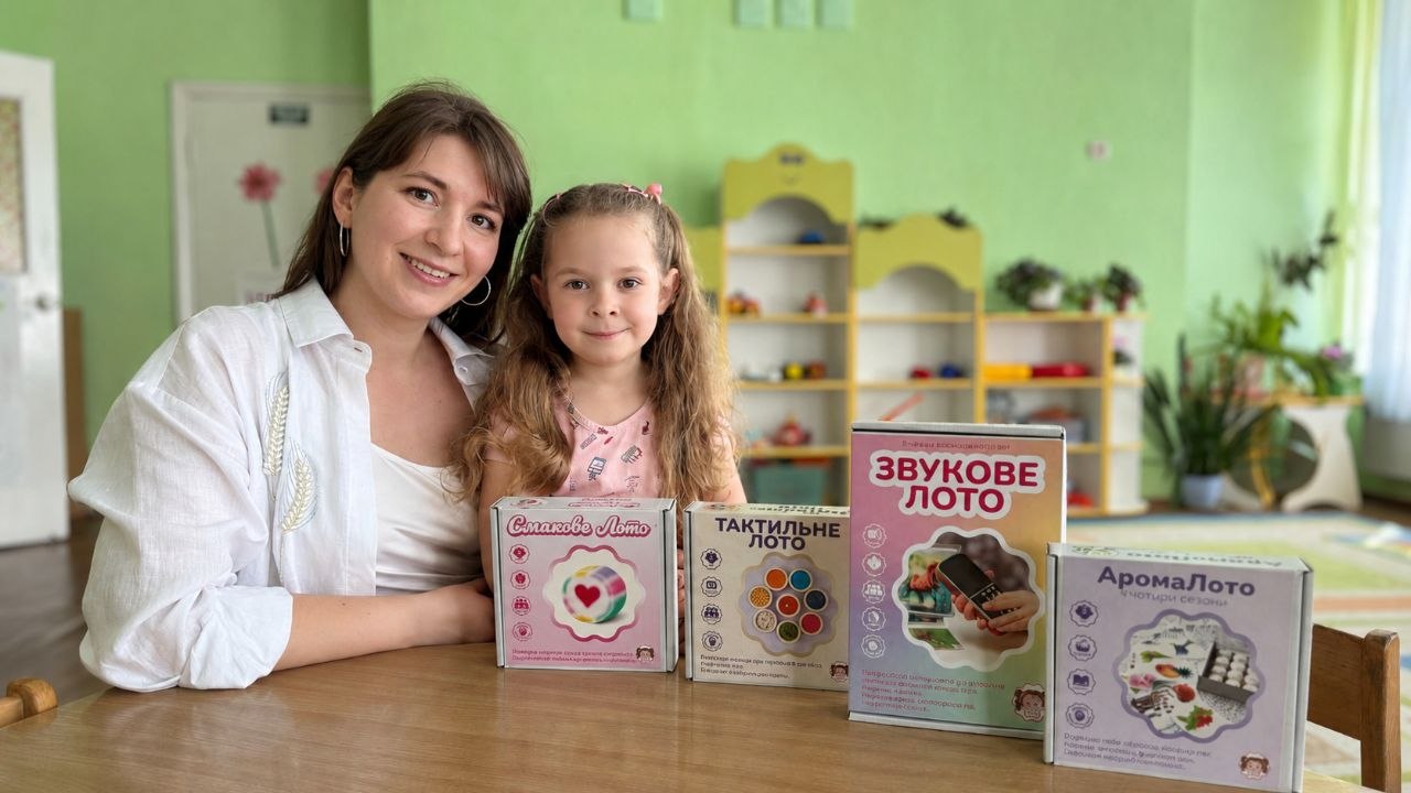 A woman and a little girl displaying four games.