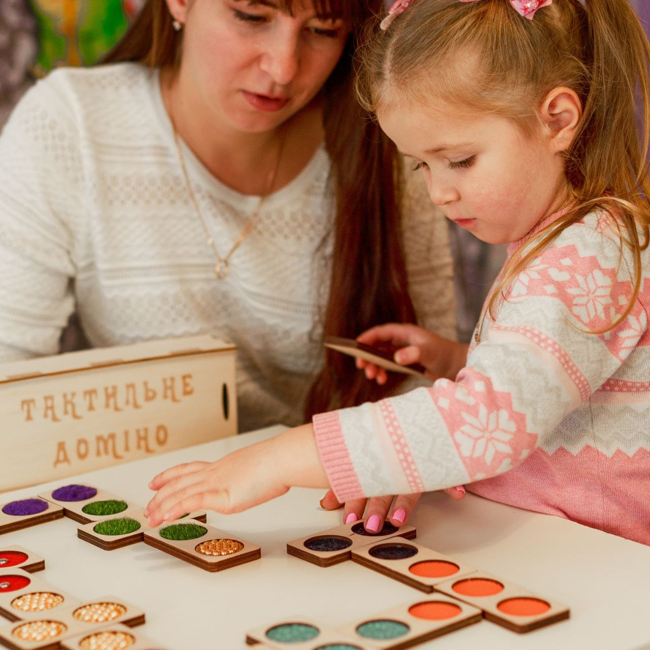 A mother and child play a game together.